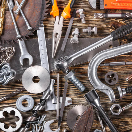 HardwareAn assortment of tools and hardware scattered on a wooden surface, including pliers, a wrench, bolts, nuts, and saw blades, conveying a theme of craftsmanship.
